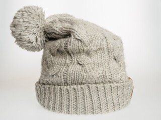 Gray knitted hat on a white background, a stylish and warm accessory for cold weather, suitable for any wardrobe