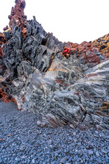 A tourist man on Djupalonssandur beach on the Snaefellsnes peninsula in winter in Iceland