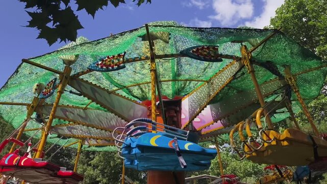 Empty colorful kiddie rides running in amusement park, Beijing, China. 