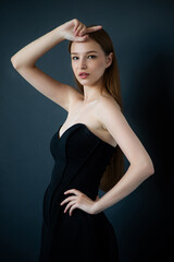 Fototapeta premium beautiful young woman wearing short black dress, studio shot.