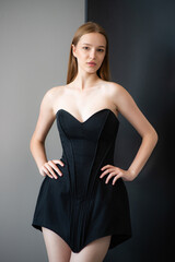 Fototapeta premium beautiful young woman wearing short black dress, studio shot.