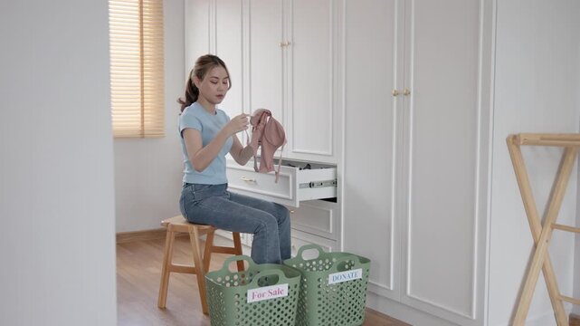 Young adult woman asia people arrange stack undies sale manage used old bra bank neat basket box clean house closet eco care. Happy asian smile go green wife home chores net zero waste fabric issue.
