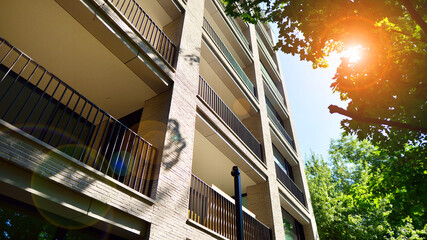 Modern residential building with new apartments in a green residential area. Eco architecture. Green tree and new apartment building. The harmony of nature and modernity.