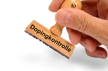 Ein Holzstempel ist beschiftet mit dem Aufdruck: Dopingkontrolle