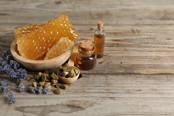 Natural honey tincture, lavender, propolis granules and sweet honeycombs on wooden table, space for text