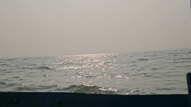 Landscape horizon view. Fishing boat moored with ocean waves and evening light at sunset at Chilika Lake. Odisha state on the east coast of India, mouth of the Daya River, flowing into Bay  Of Bengal.
