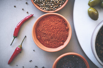 Above, bowl and curry in gray background for spices, powder and variety for sensory appeal with culinary. Studio, condiment or flavor for cooking with ingredients, texture or seasoning collection