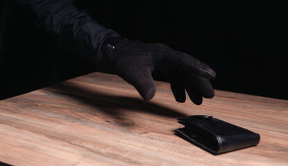 a hand in black gloves is in a dark wooden background, the concept of security, personal security