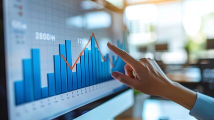 Analyst Pointing Towards Graph on Computer Screen to Explain Trend