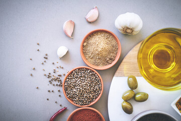 Bowl, herbs and board in gray background for spices, powder and sensory appeal for creativity with culinary. Studio, condiment and flavor for cooking with ingredients, aroma and seasoning collection
