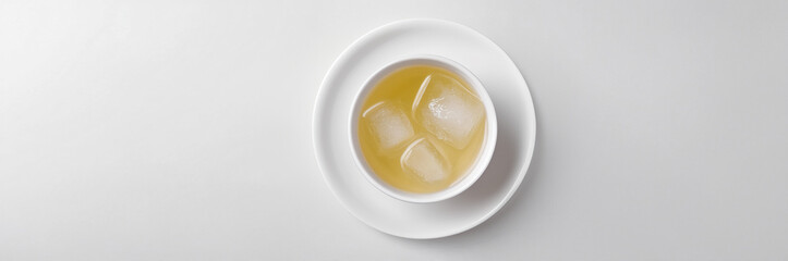 Top-Down View of a Cup of Iced Green Tea with Ice Cubes

