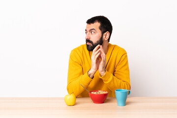 Caucasian man having breakfast in a table scheming something.