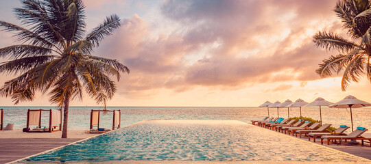Outdoor luxury sunset over infinity pool swimming summer beachfront hotel resort, tropical landscape. Beautiful tranquil beach tourism panoramic vacation. Amazing island sunset beach view, palm trees