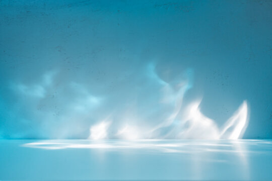 Simple abstract light blue background for product presentation with sun light reflections and shadows on wall. Winter background.
