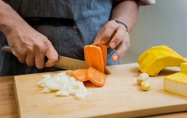 Chef at the kitchen preparing pumpkin porridge with tofu and vegetables