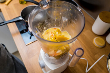 Chef at the kitchen preparing pumpkin porridge with tofu and vegetables