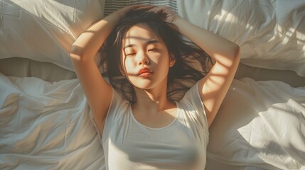 Fototapeta premium Asian women wake up from sleep. are stretch herself in the morning on the weekend sit on the bed at luxury room in Relax and weekend concept. 