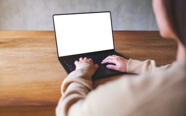 Mockup image of a woman working and typing on laptop computer with blank white desktop screen