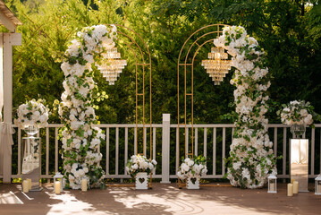 Outdoor wedding photo zone decorated with flowers.