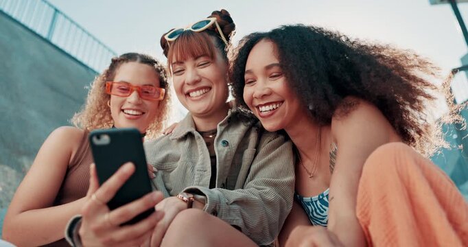 Happy woman, friends and laughing with phone for funny joke, social media or humor in cool outdoor fashion. Female person or group smile in relax on mobile smartphone for online chatting or meme