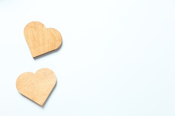 Wooden hearts on white background, top view
