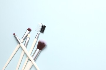 Cosmetic brushes on colored background. Set of makeup brushes