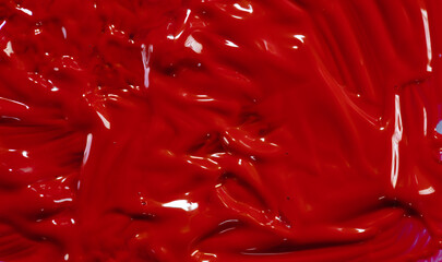 Closeup of red fluid paint textured background