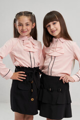 A girl of European origin in a school uniform on a white background. Smiling at the camera