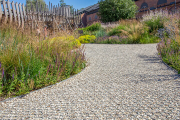 A path with a stone walkway and a fence in the background