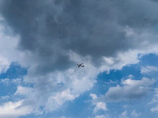 Distant Wings Under a Lilac Sky - A lone airplane soars through a serene sky painted with soft lilac and white clouds