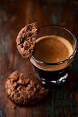 Chocolate cookie and Coffee in glass cup on rustic wooden background. Close up.	