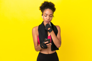 Young African sport woman isolated on yellow background thinking and sending a message