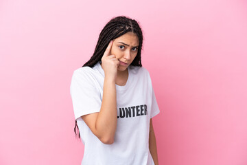 Teenager volunteer girl with braids isolated on pink background thinking an idea