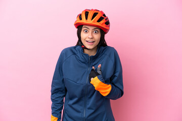 Teenager cyclist girl isolated on pink background with surprise facial expression