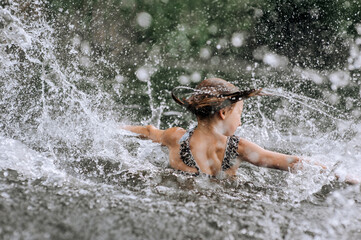 Happy beautiful smiling girl, child teenager having fun, laughing, splashing water, tumbling in the...