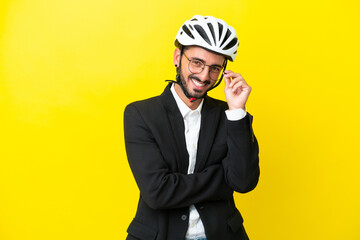 Business caucasian man with a bike helmet isolated on yellow background with glasses and happy