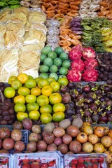 The image showcases a vibrant fruit market display with a variety of colorful fruits arranged neatly, including dragon fruit, mangoes, and strawberries, creating an appealing visual feast.