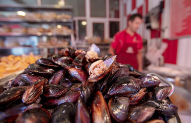 Street Flavors Stuffed Mussels. Hand Holding Mussel. Heap of Black Shellfish.
