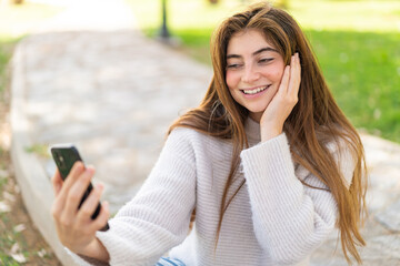 Fototapeta premium Young pretty caucasian woman using mobile phone