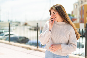 Fototapeta premium Young pretty caucasian woman with glasses at outdoors smiling a lot