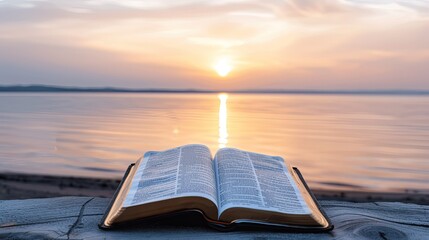 Open Bible by Serene Lakeside at Sunrise With Reflective Water