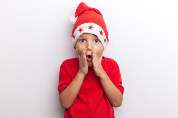 a little santa, a child in a red hat on Christmas Eve thinks about a gift. white background, studio, isolated,