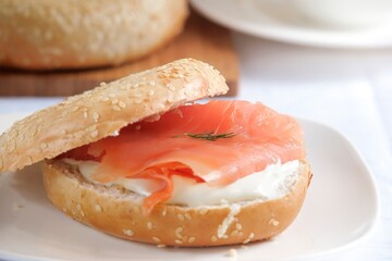 Gourmet Delight: Close-Up 4K Image of a Sesame Bagel Loaded with Cream Cheese and Succulent Smoked Salmon
