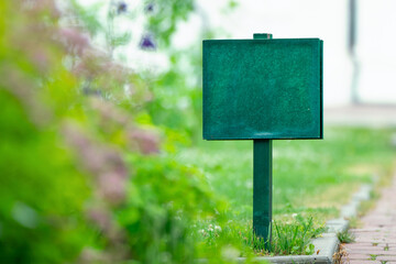 The green information board mockup integrates seamlessly into the verdant garden setting