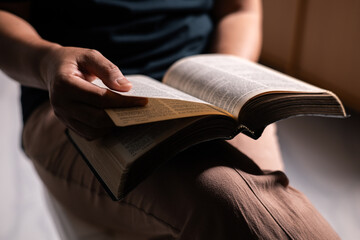 Woman of faith holds the Bible in her hand, believing deeply in the teachings of Jesus Christ and the presence of God, embodying her Christian religion. bible, person, hand, religion, book, faith.