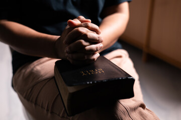 Woman of faith holds the Bible in her hand, believing deeply in the teachings of Jesus Christ and...