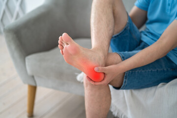 Foot pain, corns and calluses, dry skin on legs, man suffering from feet ache, podiatry concept