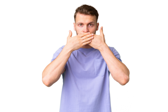 Young handsome caucasian man over isolated chroma key background covering mouth with hands