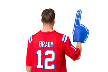 Young caucasian sports fan man over isolated chroma key background in back position