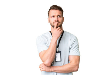 Young caucasian man with ID card over isolated chroma key background having doubts while looking up